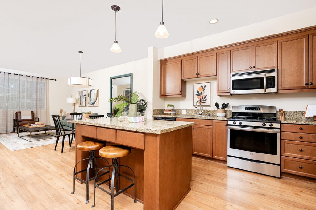 Kitchen with a granite countertop, island, and modern appliances.