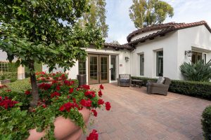 Outdoor lounge area with orange trees and comfortable seating.