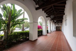 Outdoor corridor with arched architecture and hanging lanterns.