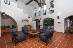 Courtyard of an apartment complex with arches and palm trees at dusk.