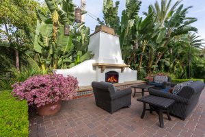 Outdoor lounge area with a fireplace and seating.