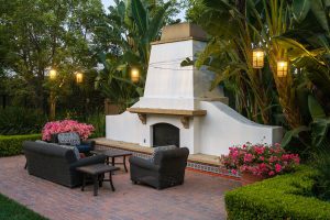 Outdoor lounge area with a fireplace and seating.