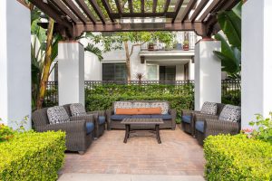 Poolside seating area with lounge chairs and a pergola.