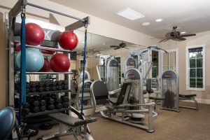 Fitness center with elliptical machines and large windows.