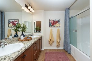 Bathroom with colorful towels, shower, and decorative artwork.