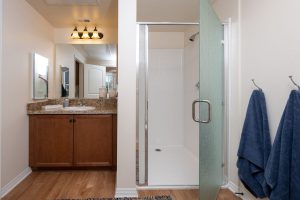 Bathroom with colorful towels, shower, and decorative artwork.
