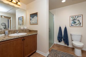 Bathroom with colorful towels, shower, and decorative artwork.