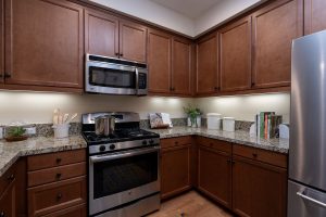 Kitchen with a granite countertop, island, and modern appliances.