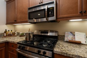 Kitchen with a granite countertop, island, and modern appliances.