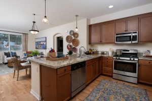 Kitchen with a granite countertop, island, and modern appliances.
