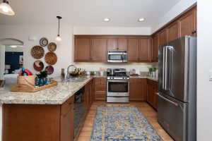 Kitchen with a granite countertop, island, and modern appliances.