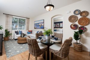 Cozy living room with sofa, chair, and wall art and a dining table.