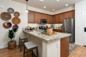 Kitchen with a granite countertop, island, and modern appliances.